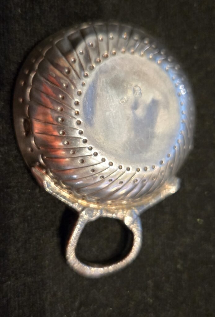 20260313 161527 Exceptionnel petit taste-vin (tâte-vin) de dégustation en argent massif de style Louis XVI, réalisé sous le Premier Empire. Cette pièce de maîtrise se distingue par son décor classique et élégant, composé de godrons rayonnants et d'une double rangée de perles en relief sur le fond. L'anse est formée d'un serpent entrelacé finement ciselé, symbole traditionnel des vignerons de Bourgogne.